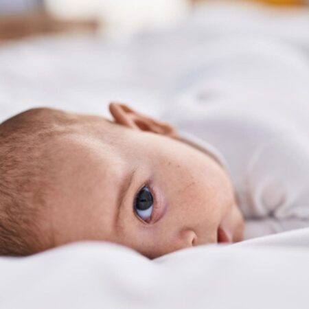 Bebis som sover med öppna ögon och ovanliga andningsmönster